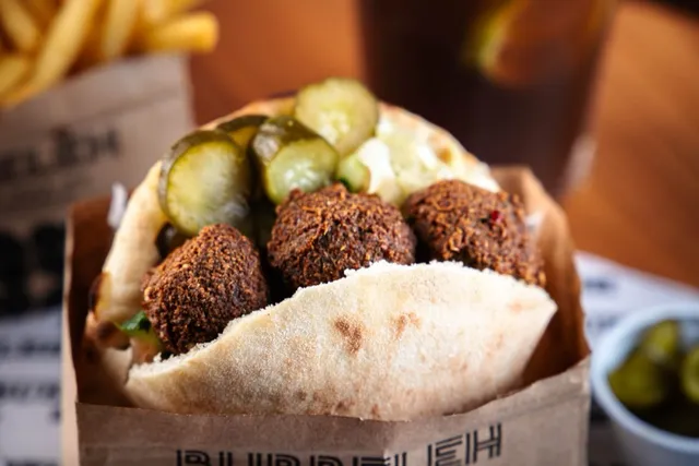 Falafel do Bubbeleh: bolinhos de grão-de-bico dourados com homus, tahine e salada no pão pita
