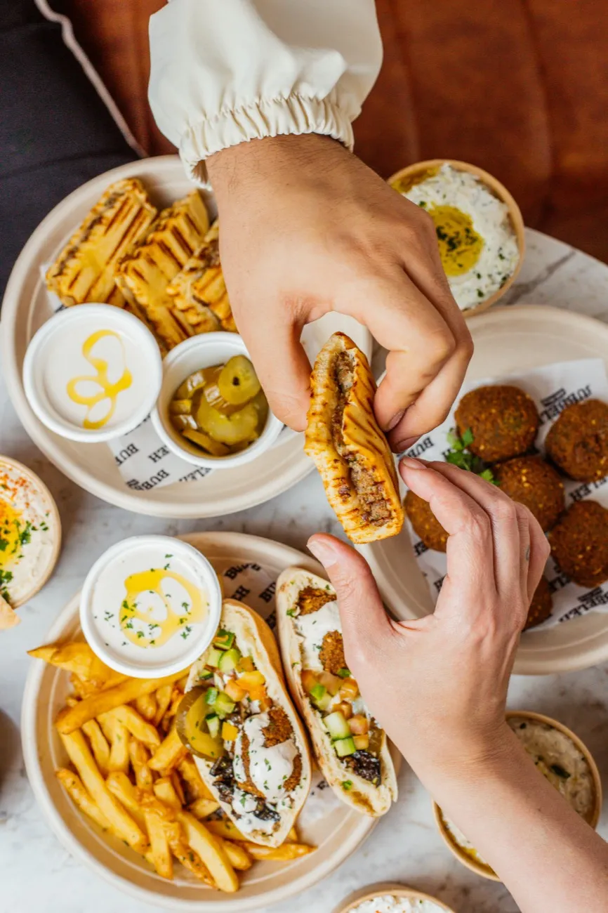 Mesa compartilhada no Bubbeleh: arais, falafel, pastas, picles e batata frita